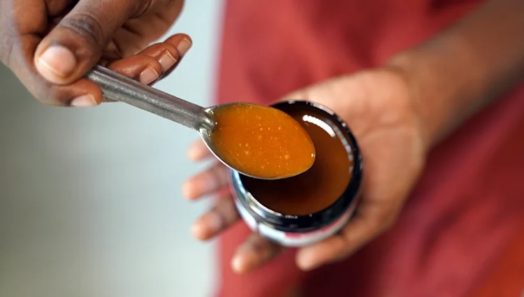 a person tasting a spoonful of manuka honey to explore its rich and complex flavor profile