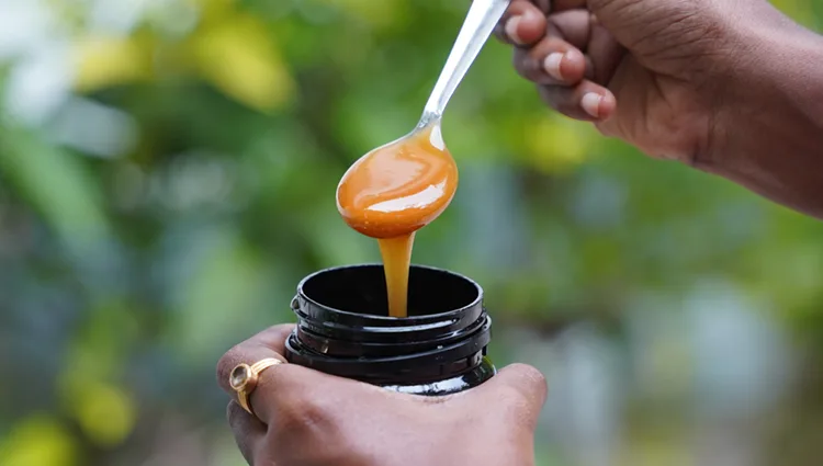 spoon with manuka health honey slowly dripping