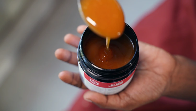 viscous manuka honey dripping from a spoon